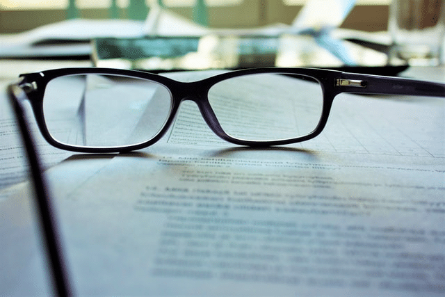 Reading glasses on a real estate agreement drafted by a lawyer