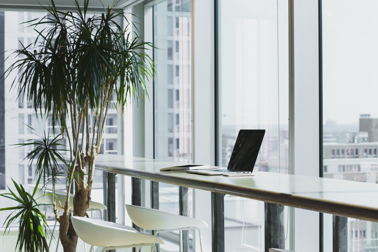 Nanda & Associate Lawyers Canada - Laptop on desk with a white stool in a glass office overlooking the city