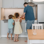 Nanda & Associate Lawyers Canada - A father cooking in the kitchen with his young son and daughter