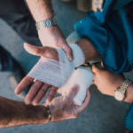 Nanda & Associate Lawyers Canada - Applying bandage on a person’s hand.