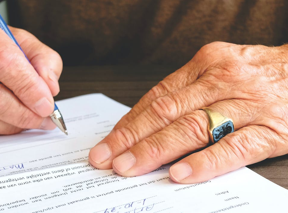 Nanda & Associate Lawyers Canada - A person signing a document